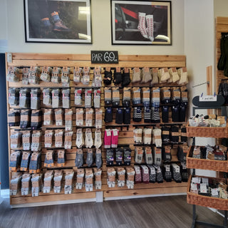 Sokkevæg i Skind og Ulds butik med et stort udvalg af uldsokker i forskellige farver og mønstre.