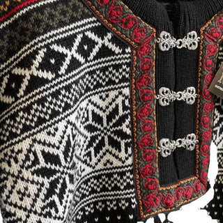 Den norske uldsweaters mønster og røde halsåbning med tinhægter, vist tæt på.