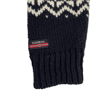Marineblåt ærme med hvidt mønsterbånd, ribmanchet og mærke på den islandske uldsweater.