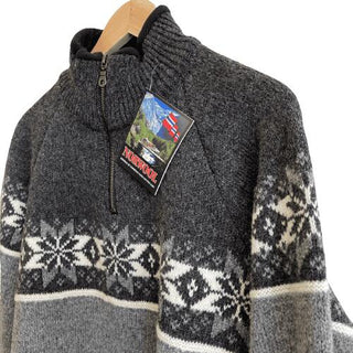 Grå og koksgrå raglansweater med nærbillede af stjernemønster, høj krave og kort lynlås.