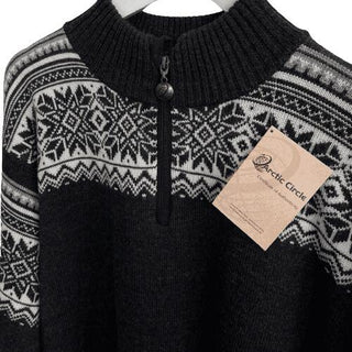 Sort ribkrave, lynlås og hvidt nordisk mønster på den koksgrå merinouldsweater, vist tæt på.