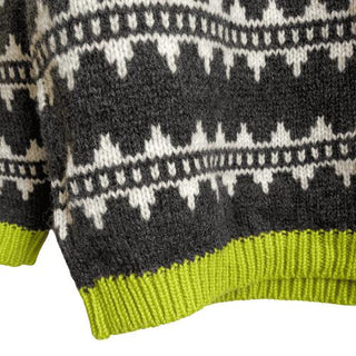 Limegrøn ribkant og sorte og hvide mønsterbånd på den islandske uldsweater.