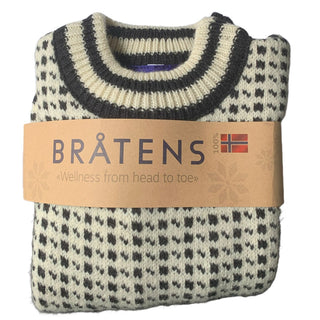 Råhvid Bråtens-uldtrøje til børn med mørkt mønster og stribede ribkanter, foldet og samlet med banderole.