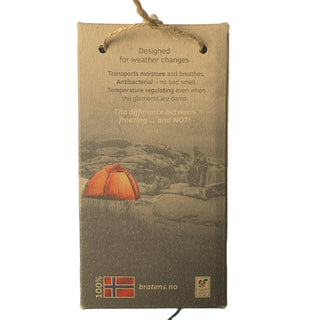 Emballagens bagside til sort halsedisse i merinould, med produktinformation.