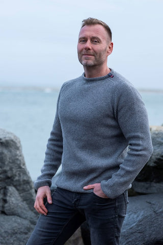 Grå Jurmo-uldtrøje fra WOOLWEAR med rund hals, båret af en model.
