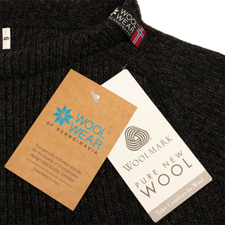 Halskant og WOOLWEAR-mærker på den koksgrå Jurmo-uldtrøje.