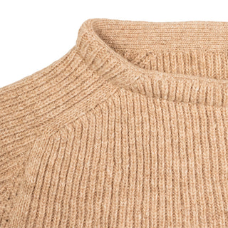 Rund ribstrikket halskant på den beige Jurmo-uldtrøje.