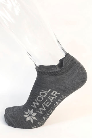 Grå merinouldfootie med WOOL WEAR-logo, vist på en fod.