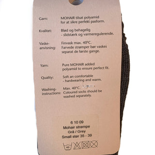 Emballagens bagside til koksgrå mohairuldsokker, med produktinformation.