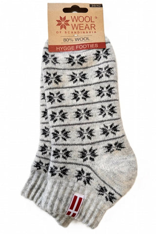 Lyse uldfooties med sorte mønstre og dansk flag, med produktmærke.
