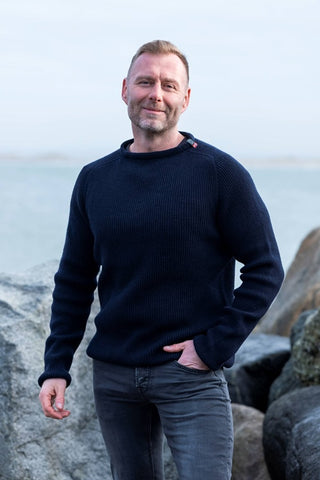 Marineblå Jurmo-uldtrøje fra WOOLWEAR med rund hals, båret af en model.